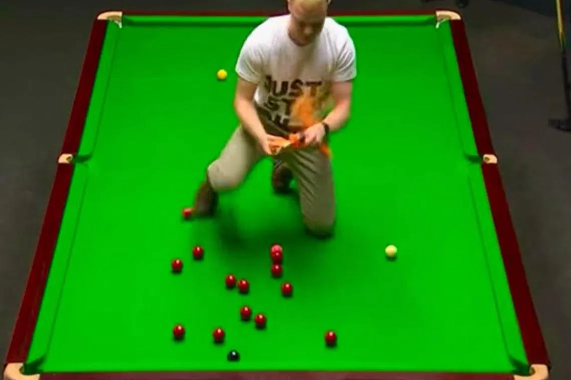 The man jumped onto the table and emptied a bag of orange powder across the green baize.