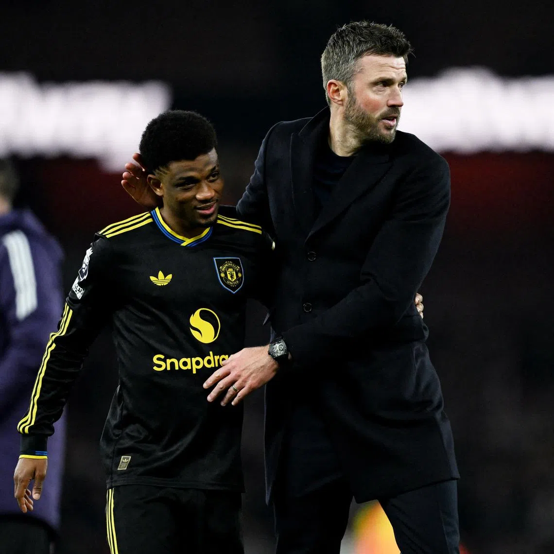 Soccer Football - Premier League - Arsenal v Manchester United - Emirates Stadium, London, Britain - January 25, 2026 Manchester United's Amad Diallo celebrates after the match with Manchester United manager Michael Carrick REUTERS/Dylan Martinez