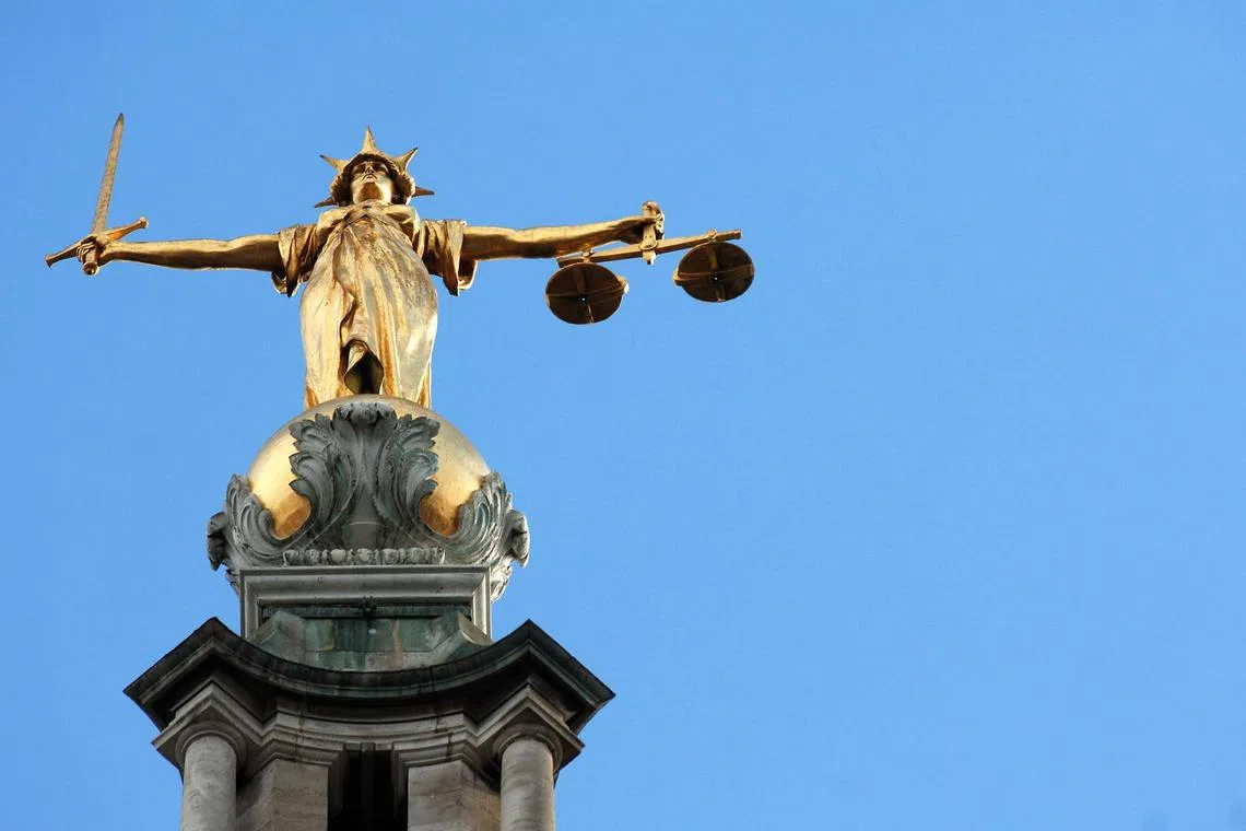 View of the gold statue of the figure of justice, holding scales and a sword, on top of the Central Criminal Court, also referred to as Old Bailey, in central London.