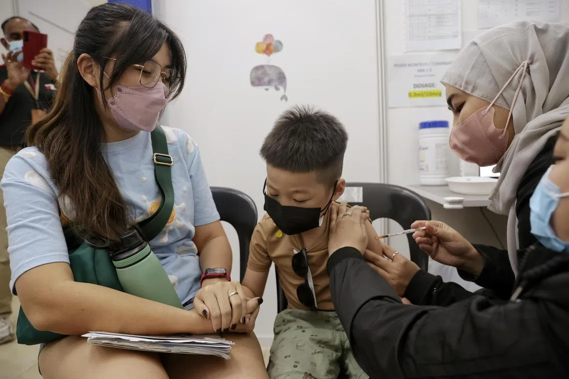Five-year-old Jaden Tan, accompanied by his godmother Zhang SY, receiving the updated Pfizer-BioNTech/Comirnaty vaccine at Ang Mo Kio JTVC on Nov 4.
