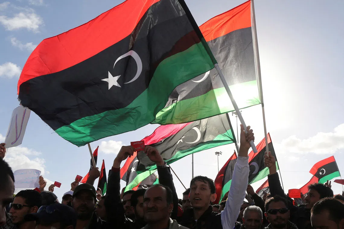 FILE PHOTO: People wave Libyan flags during a demonstration in Benghazi February 7, 2014.  REUTERS/Esam Omran Al-Fetori/File Photo