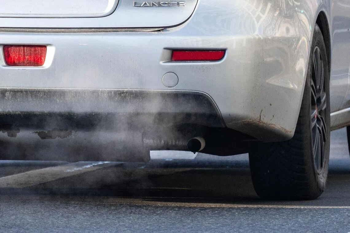 An exhaust pipe of a car with a combustible engine expels fumes in Berlin on December 16, 2025. The European Union looks set to scrap a landmark 2035 ban on new petrol and diesel cars on December 16, as part of a package of reforms aimed at supporting Europe's embattled auto industry. The ban was hailed as a major win in the fight against climate change when it was adopted in 2023, but carmakers and their backers have lobbied hard over the past year for Brussels to relax it, in the face of fierce competition from China and a slower-than-expected shift to electric vehicles (EVs). (Photo by John MACDOUGALL / AFP)