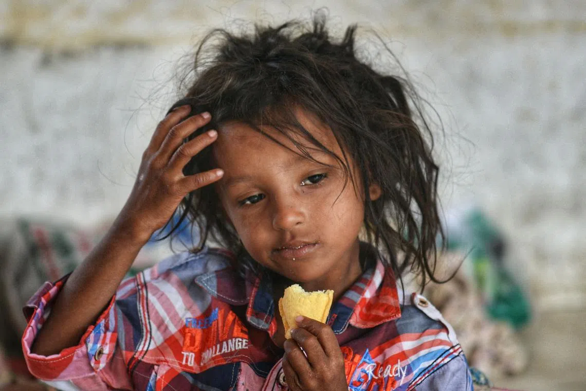 A Rohingya refugee eats a biscuit at a temporary shelter following his arrival by a boat in Laweung, Aceh province on December 27, 2022. Rohingya refugees received emergency medical treatment after a boat carrying nearly 200 people came ashore in Indonesia on December 26, authorities said, in the fourth such landing in the country in recent months. 