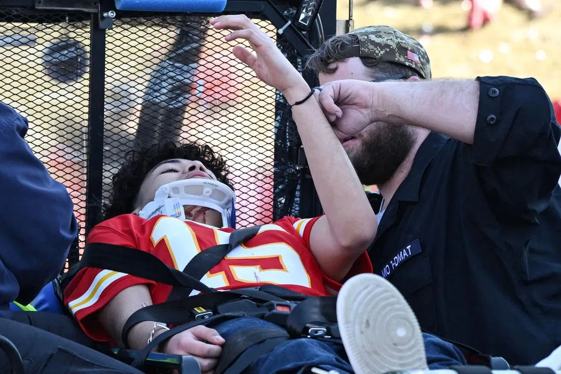An injured person receives help after gun shots were fired at a parade to celebrate the Kansas City Chiefs winning the Super Bowl. 