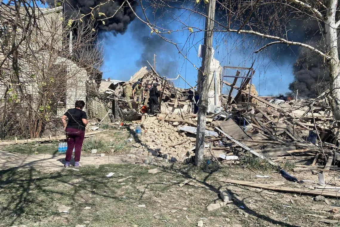 Rescuers and police working at the site of a Russian air strike, in the village of Lyptsi, in Ukraine's Kharkiv region, on April 10, 2024.