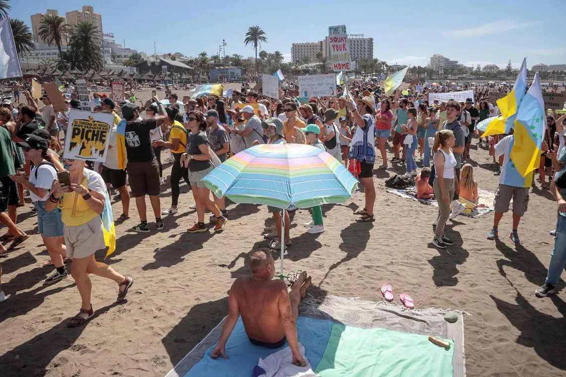 Protesters march on Las Americas beach during a demonstration to protest against mass tourism, in Arona on the Spanish Canary island of Tenerife, on October 20. The country's government has launched a probe into companies that manage short-term apartment rentals to tourists for alleged “misleading practices” as visitor numbers surge.