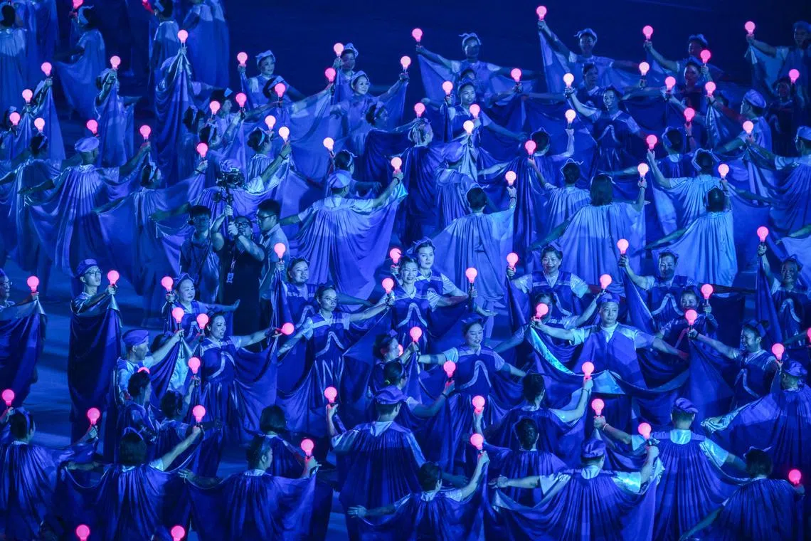 Our Future, Our Aspirations, performer glided across the stage in a rive -like formation while holding up lightsticks. 