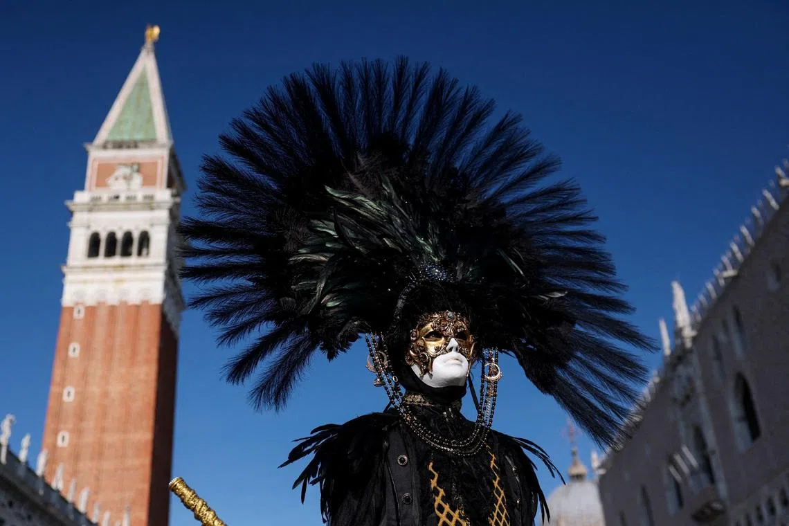 A masked reveller posing for a picture on the first day of the Venice carnival, in St. Mark's Square, in Venice, Italy, on Jan 31, 2026. 