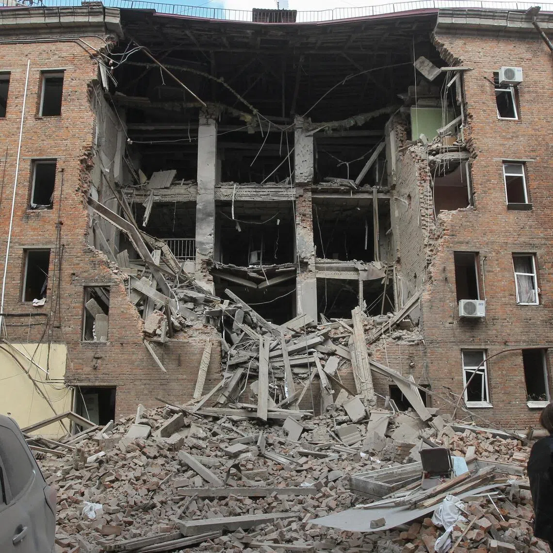 A resident stands in front of a residential building hit during a midday Russian drone strike, amid Russia's attack on Ukraine, in Dnipro, Ukraine, on April 25.