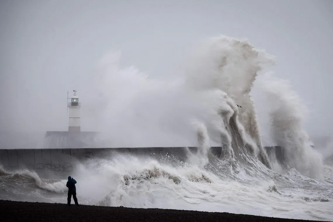 Waves crash over Newhaven Lighthouse and the breakwater in Newhaven, southern England on Jan 1, 2025, as weather warnings were put in place for rain, snow and wind across the UK. 