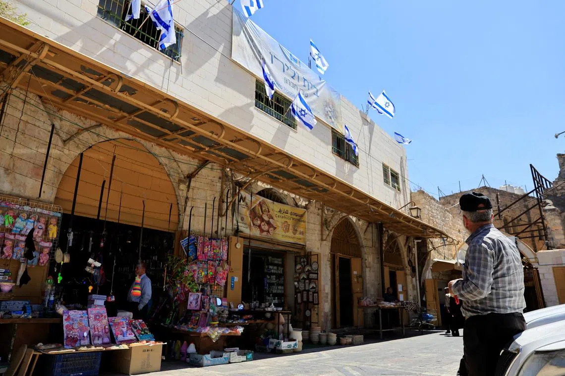 A Palestinian looks at Israeli flags placed over a house in the West Bank on Sept 3. Israel said other nations recognising Palestinian statehood would make it "harder to get to the peace."