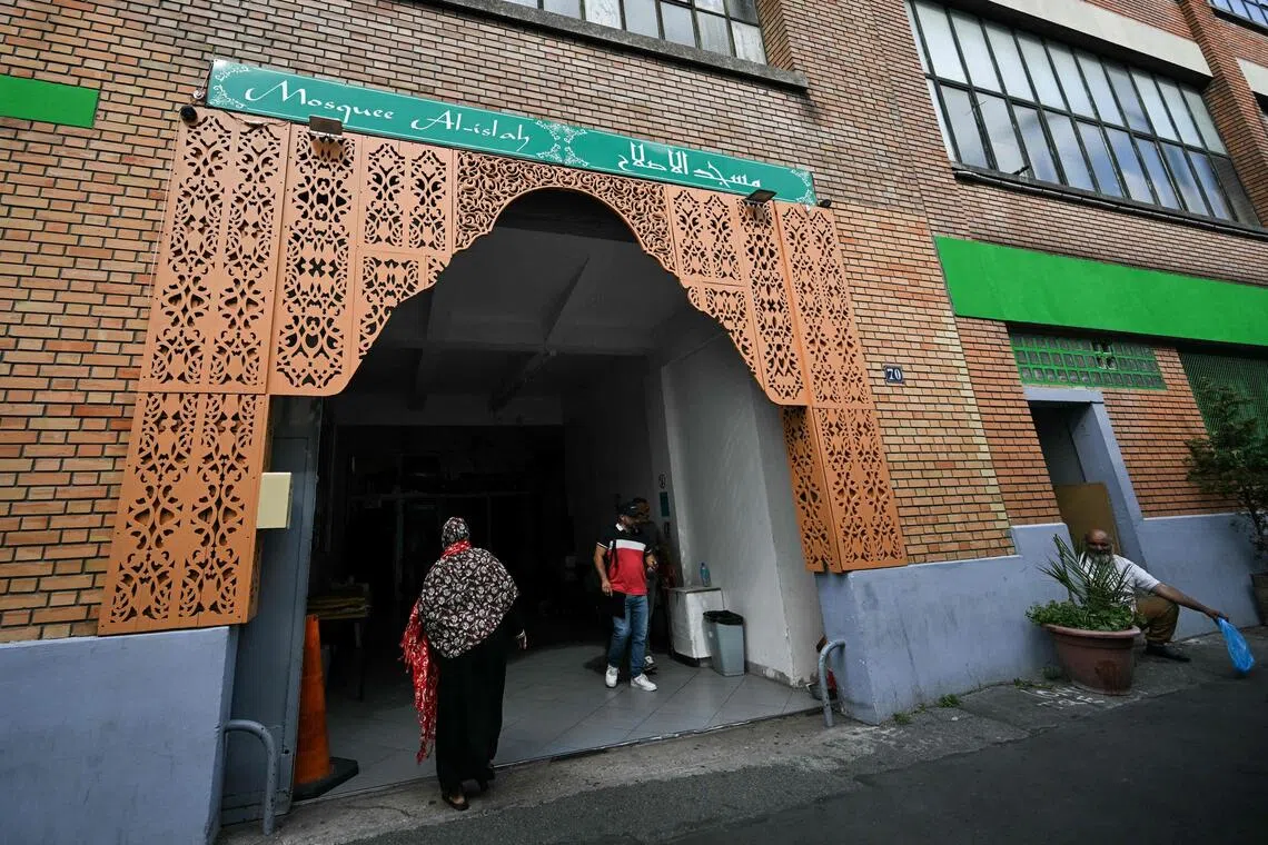 The faithful leave and arrive at the Mosque Islah, in Montreuil, Seine-Saint-Denis, on the outskirts of Paris, on Sept 9. A pig's head was discovered at the entrance of the building that day.  