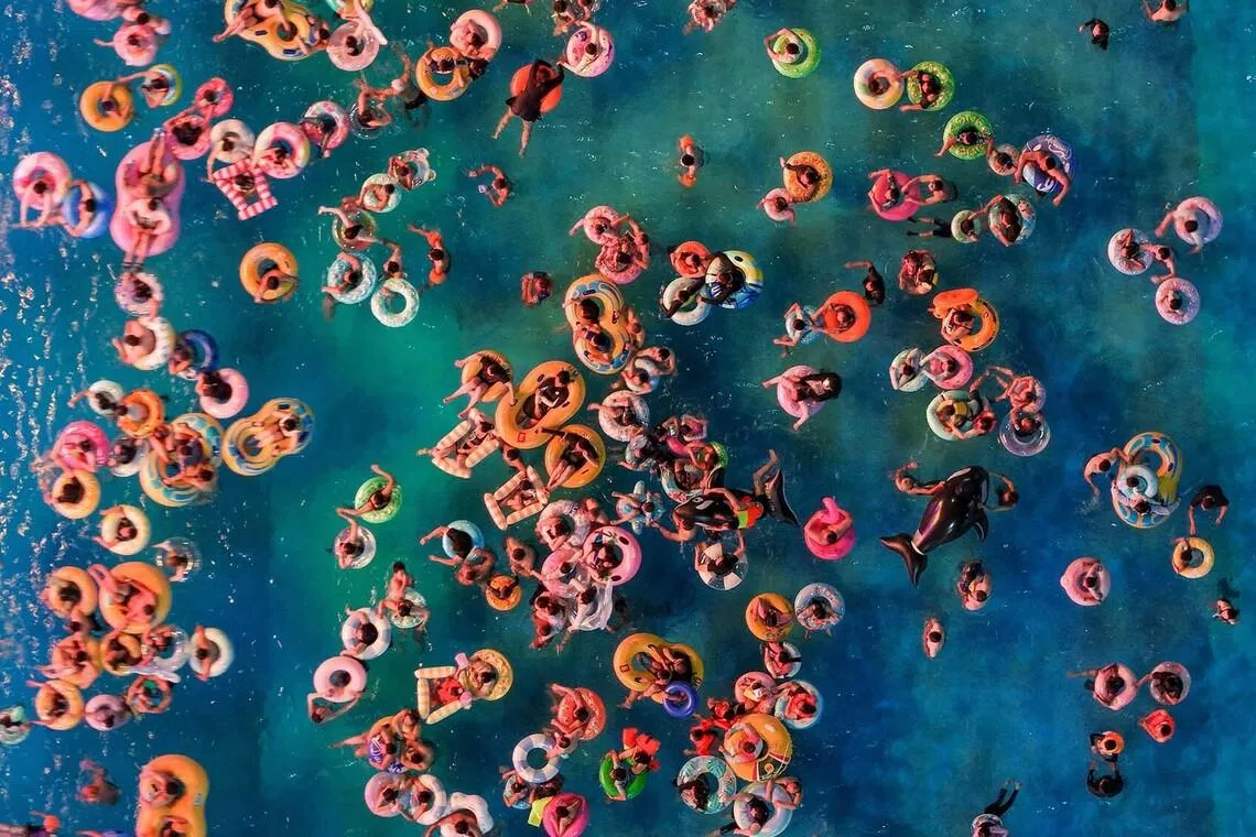 TOPSHOT - This aerial photo shows people cooling off at a water park amid hot weather in Nanjing, in eastern China's Jiangsu province on July 28, 2026. (Photo by CN-STR / AFP) / China OUT