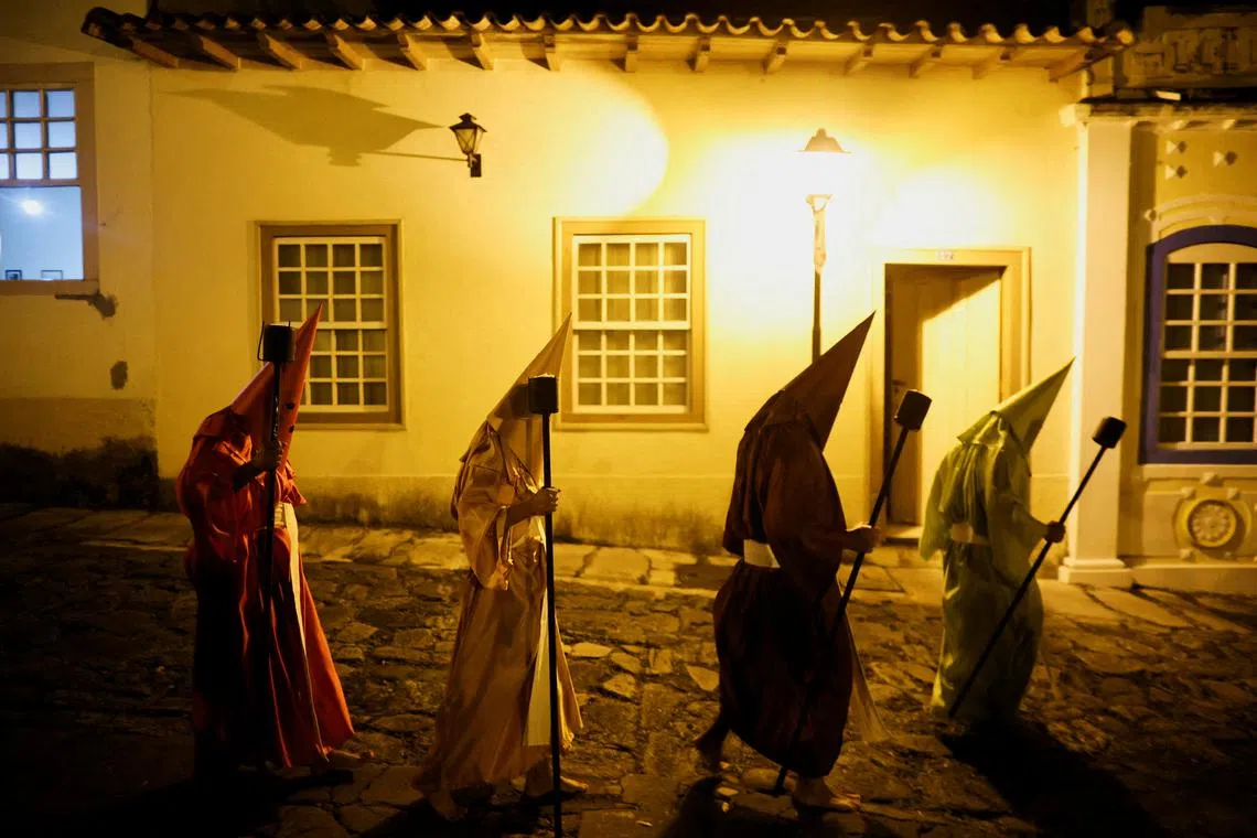 FILE PHOTO: Hooded Catholic faithful walk in the Torch Procession, known as Fogareu, during the Holy Week in Goias, State of Goias, Brazil April 16, 2025. REUTERS/Adriano Machado/File Photo