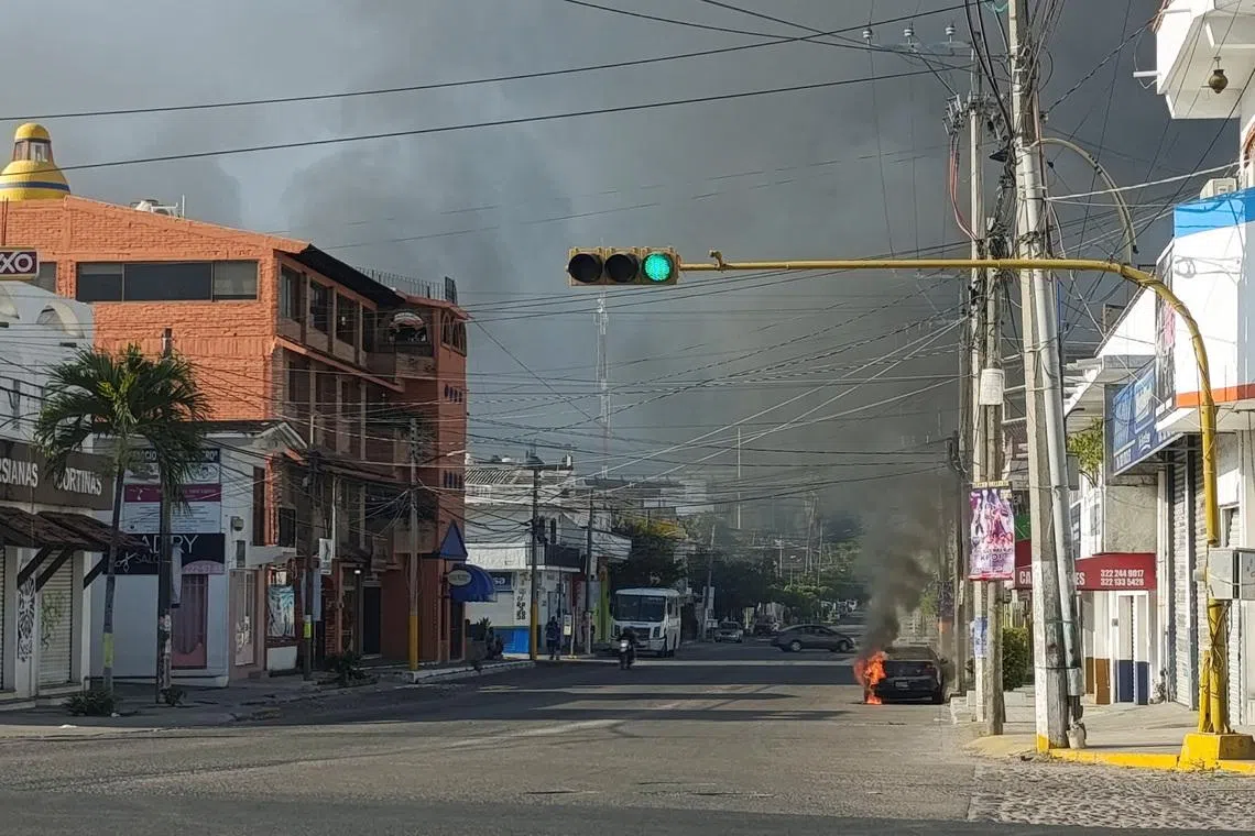 A vehicle burns after members of organised crime carried out roadblocks and burned down some businesses following a military operation against Mexican drug lord Nemesio Oseguera.
