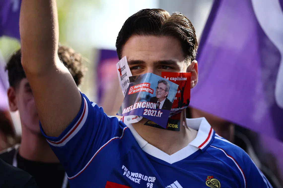 Image 5: A supporter of Jean-Luc Melenchon, leader of French far-left opposition party La France Insoumise (France Unbowed - LFI) and candidate for the 2027 French presidential election, wears stickers on his face during a demonstration by French high school and university students in Paris as part of a nationwide protest movement led by students, supported by teachers, school parents and labour unions, demanding better school conditions and concrete measures, France, October 13, 2026.   REUTERS/Sarah Meyssonnier