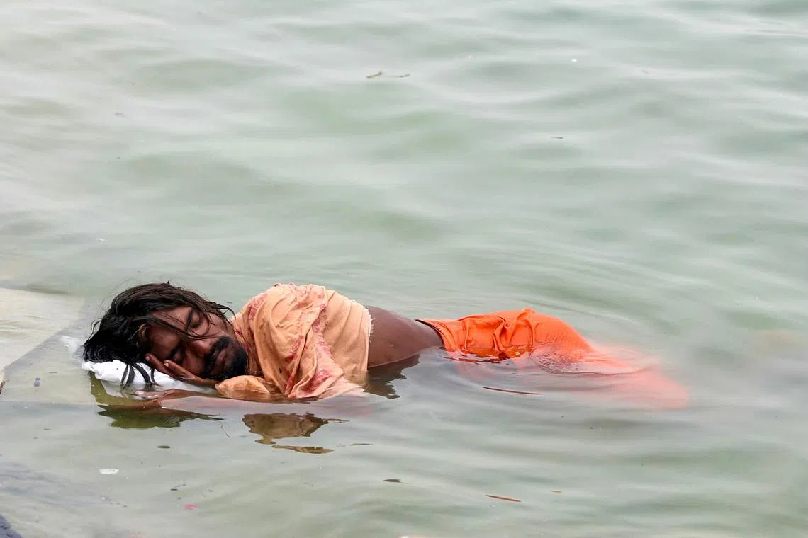 A man sleeping in the river Ganges on a hot summer day, in Varanasi, India, on June 18, 2024. 