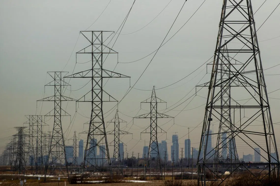 FILE PHOTO: Power lines stretch towards the city of Mississauga visible in the background in Oakville, Ontario, Canada, March 13, 2025. REUTERS/Carlos Osorio/File Photo