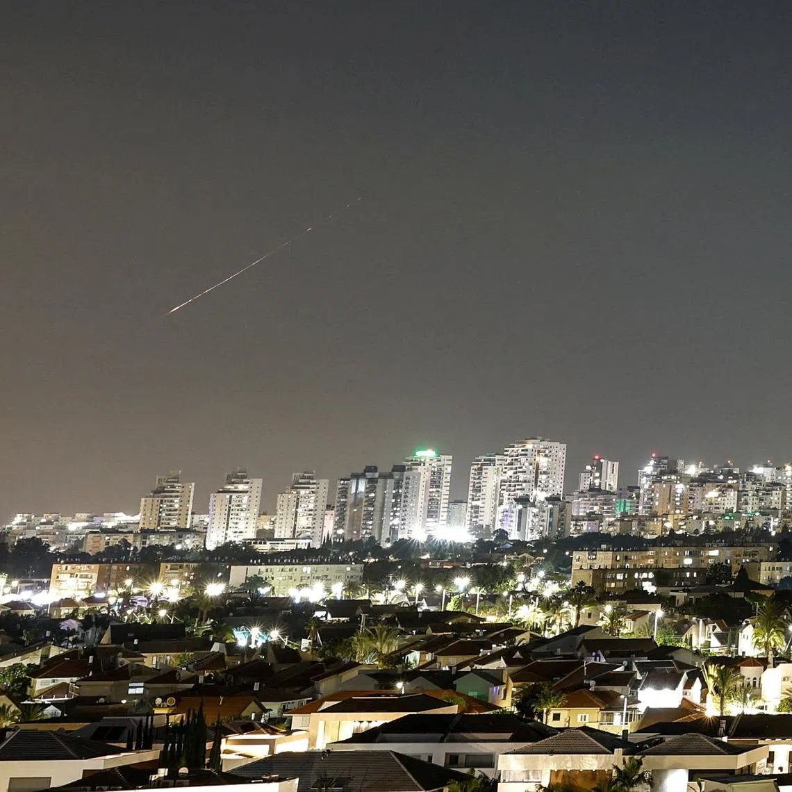 A streak of light illuminates the sky during a missile attack from Iran towards Israel as seen from Ashkelon, Israel, June 7, 2026. REUTERS/Amir Cohen