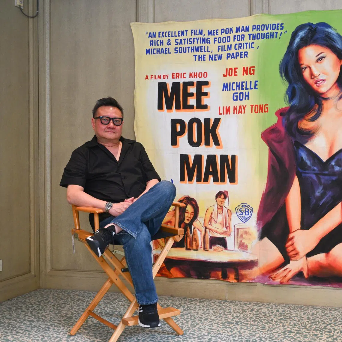 ST20250804_202599800411 Azmi Athni jseric06//

Singaporean filmmaker Eric Khoo poses with his original Mee Pok Man movie canvas used by Shaw cinema when the movie was released in 1995, on Aug 4, 2025.

ST PHOTO: AZMI ATHNI