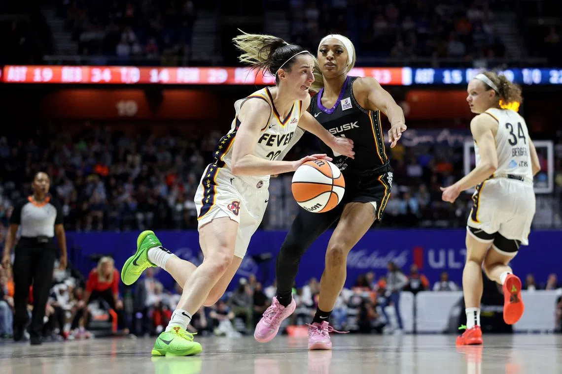 Caitlin Clark of the Indiana Fever drives against DiJonai Carrington of the Connecticut Sun during the fourth quarter at Mohegan Sun Arena.