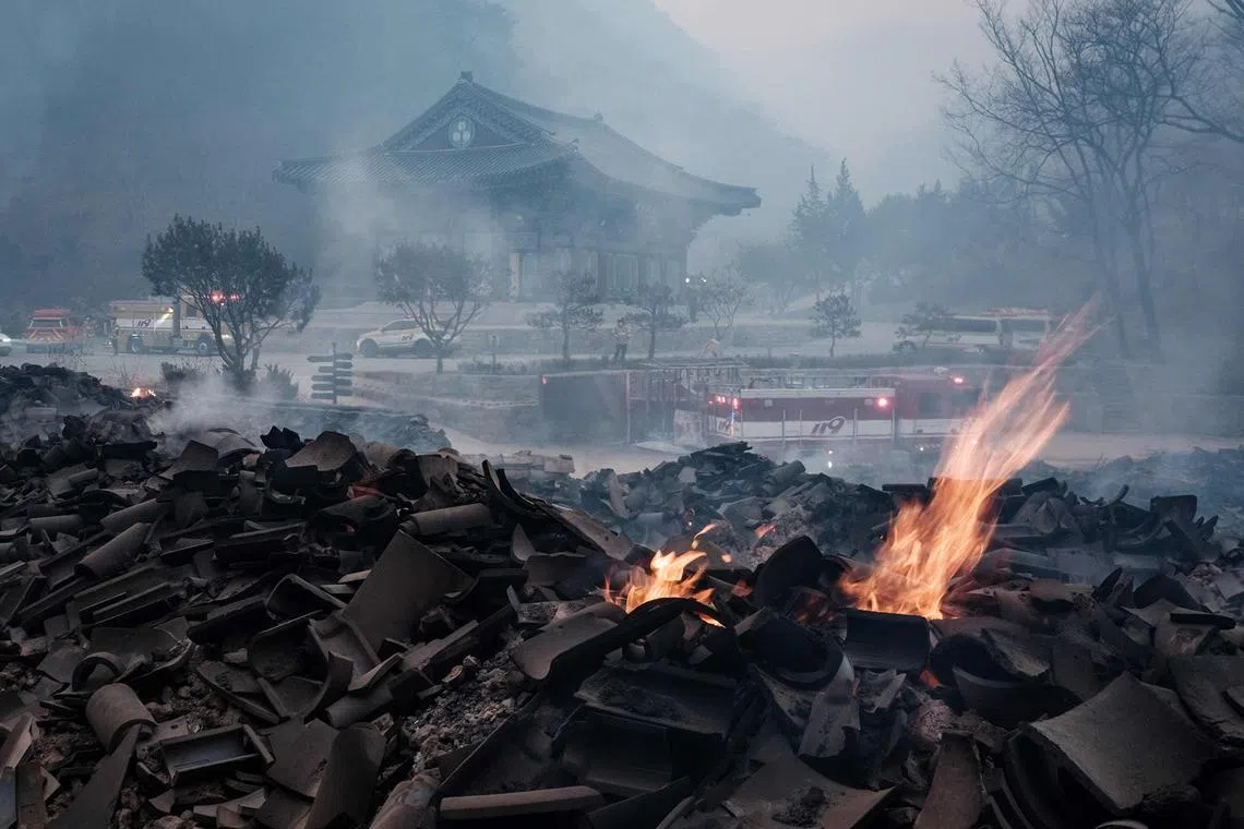 Embers burning among debris after most of the buildings were burned to the ground in a wildfire at Gounsa Temple in Uiseong, South Korea, on March 26, 2025. 