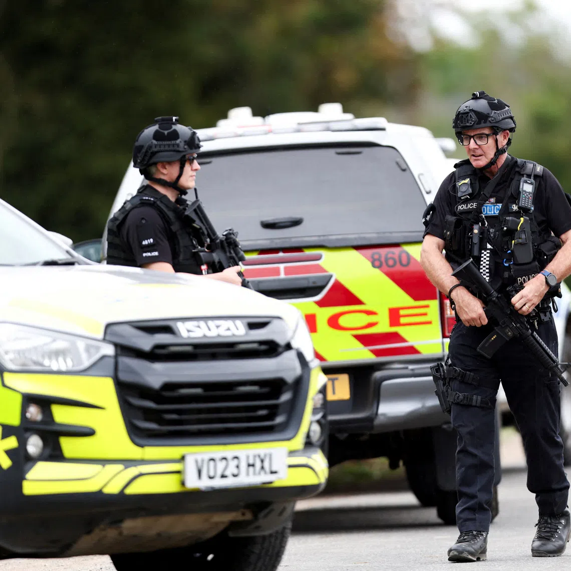 Armed police officers work on a road outside the perimeter of the RAF Fairford airbase, after police declared a major incident at the base in Fairford, Gloucestershire, Britain.