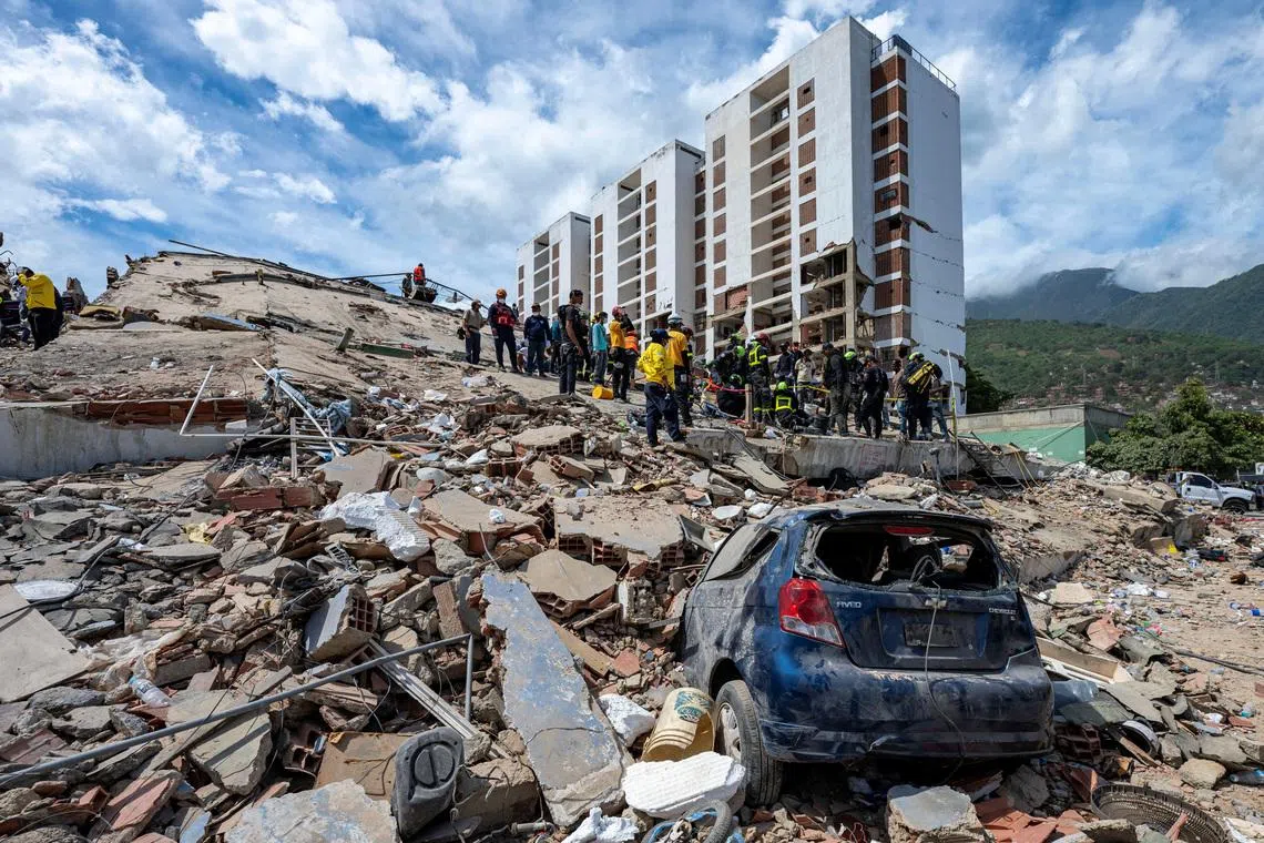 Rescuers work on the rubble of a collapsed building near a damaged vehicle in La Guaira, Venezuela, on June 28.
