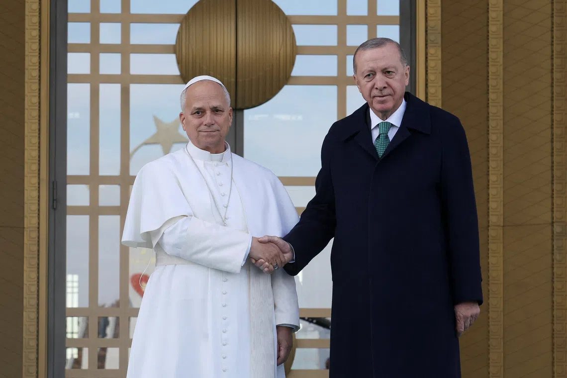 Pope Leo XIV and Turkish President Tayyip Erdogan shake hands as they meet at the Presidential Palace, during the pope's first apostolic journey, in Ankara, Turkey, November 27, 2025. REUTERS/Umit Bektas