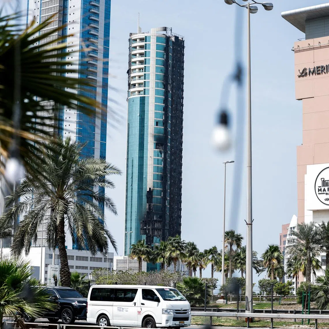 Vehicles drive past a building that was damaged by an Iranian drone attack, after Israel and the U.S. launched strikes on Iran, in Seef, Manama, Bahrain, March 1, 2026. REUTERS/Hamad I Mohammed