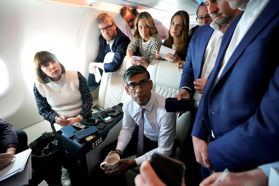British Prime Minister Rishi Sunak holds a huddle with political journalists on board a government plane as he heads to Washington on Tuesday. 