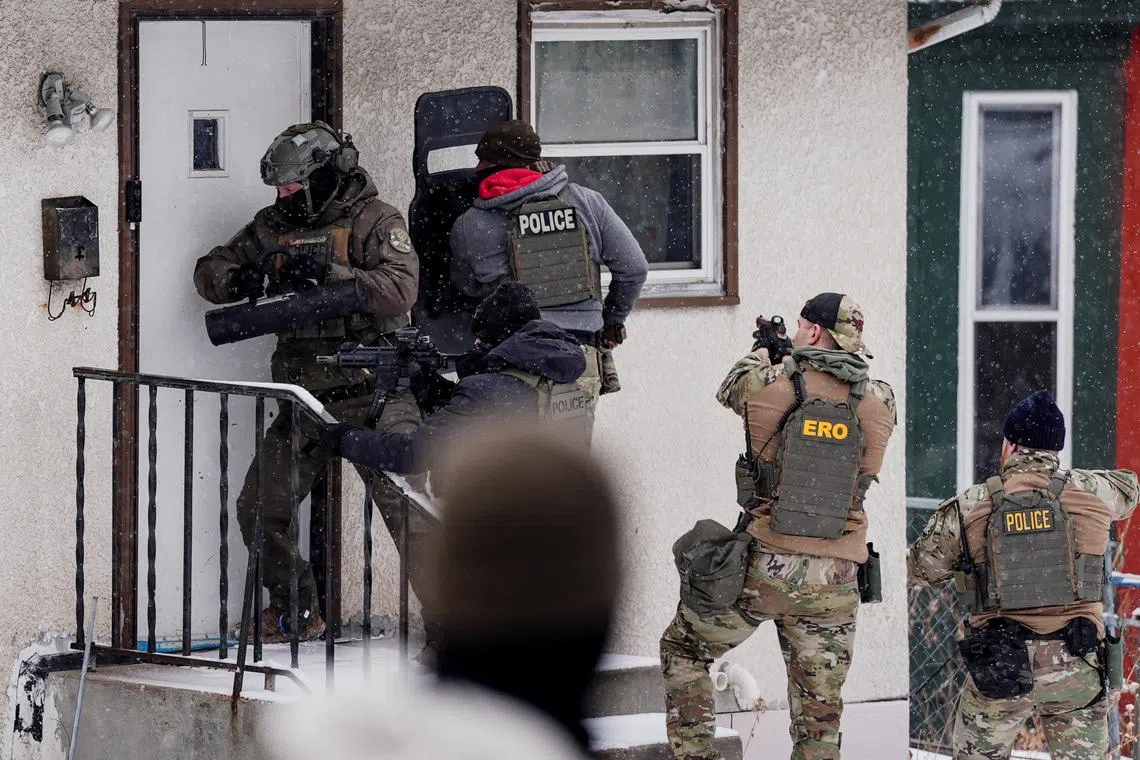 A law enforcement officer uses a battering ram to force entry into a home during an immigration raid in St. Paul, Minnesota, U.S., days after an ICE agent fatally shot Renee Nicole Good, January 18, 2026. REUTERS/Leah Millis