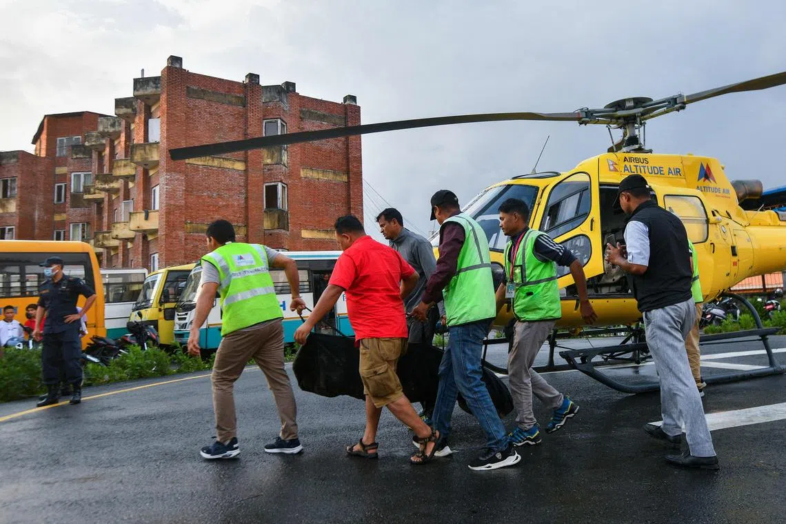 People carry the body of victim who was killed in a helicopter crash, at Tribhuvan University Teaching Hospital, Kathmandu on July 11.