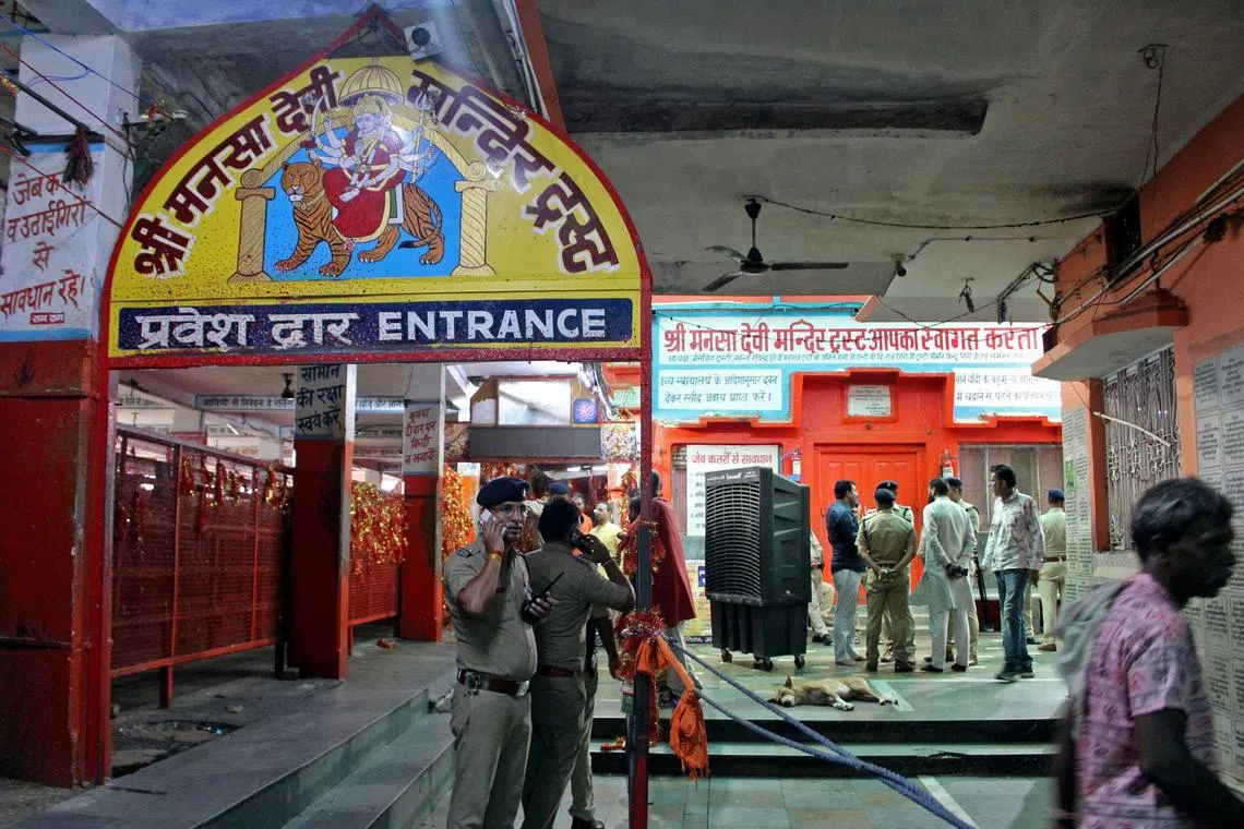 Police officials stand guard near the site of a stampede at the Mansa Devi temple in Haridwar, on July 27, 2025. At least six people were crushed to death at a popular Hindu temple in northern India's Uttarakhand state on July 27, officials said, after a massive crowd surge. (Photo by AFP)