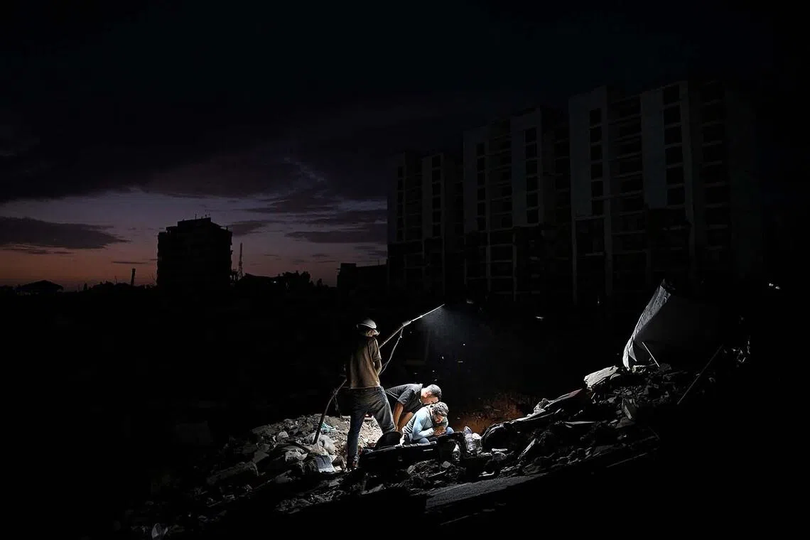 TOPSHOT - Volunteers and relatives of victims search for their loved ones amid debris of a collapsed building in Caraballeda, La Guaira state, Venezuela, on July 16, 2026. The death toll from last month's devastating twin earthquakes in Venezuela has surpassed 4,800, while 16,740 people were injured and nearly 21,000 were made homeless the government reported on July 15. (Photo by Federico PARRA / AFP)