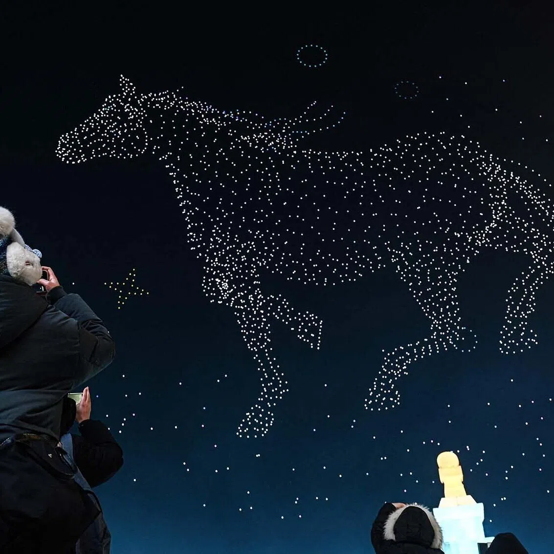 People taking photos during a drone show at the opening ceremony of the 42nd Harbin China International Ice and Snow Festival at Harbin in northeastern China’s Heilongjiang province on Jan 5, 2026. 