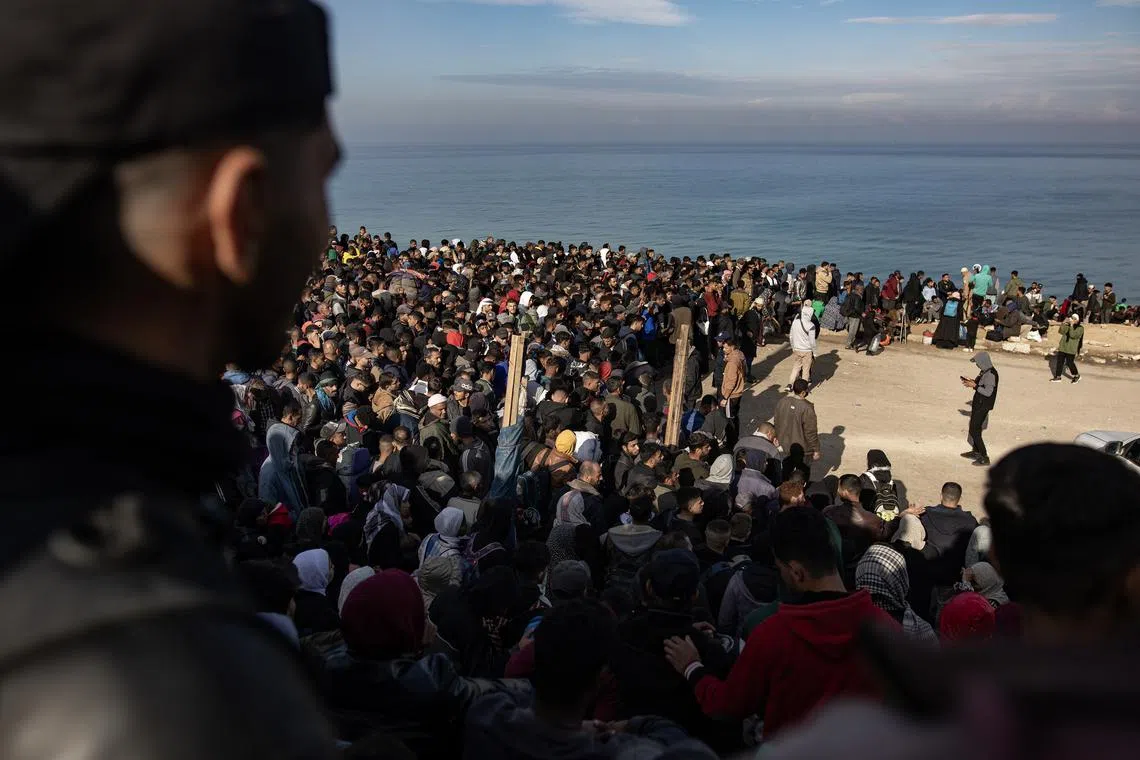 Palestinian families wait to return to the northern Gaza Strip from the southern Gaza Strip, along Rashid Road, west of Nuseirat refugee camp, central Gaza Strip, Jan 26, 2025. 