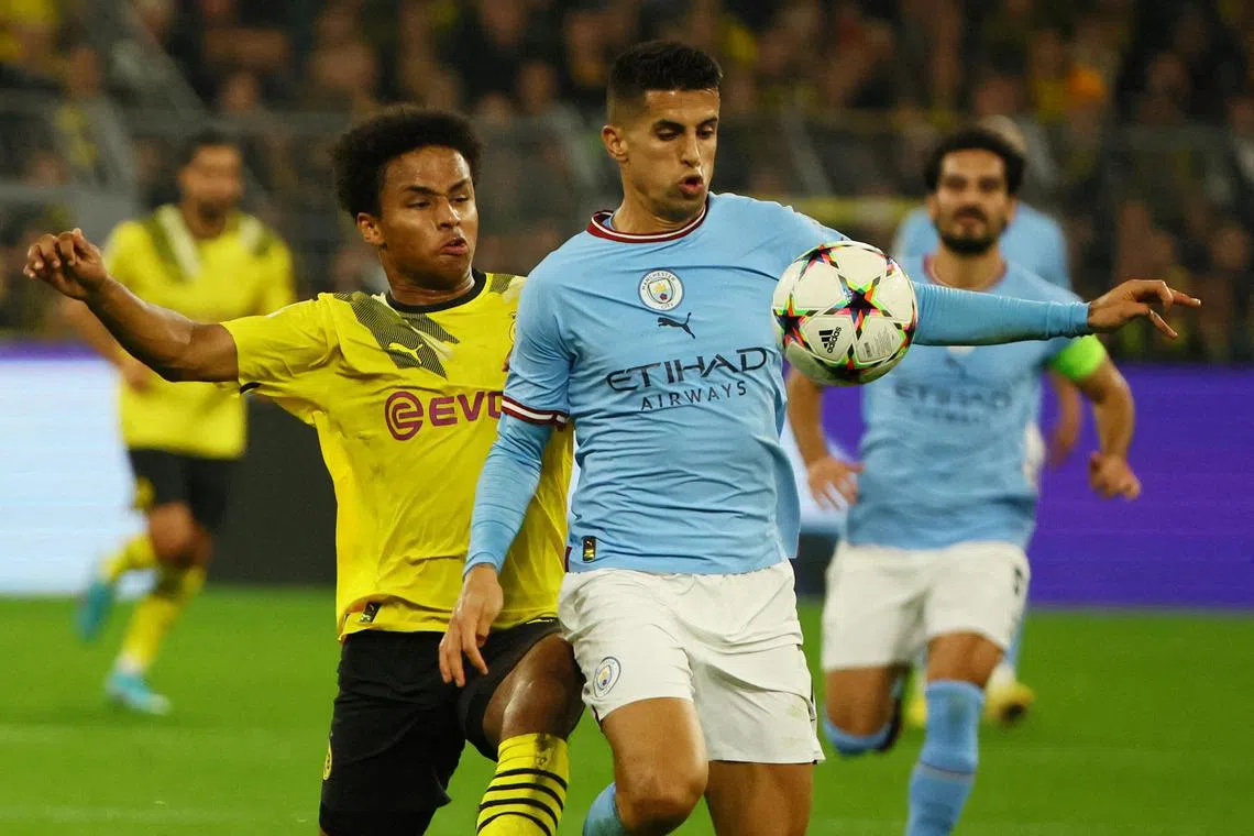 Manchester City's Joao Cancelo (right) in action with Borussia Dortmund's Karim Adeyemi.