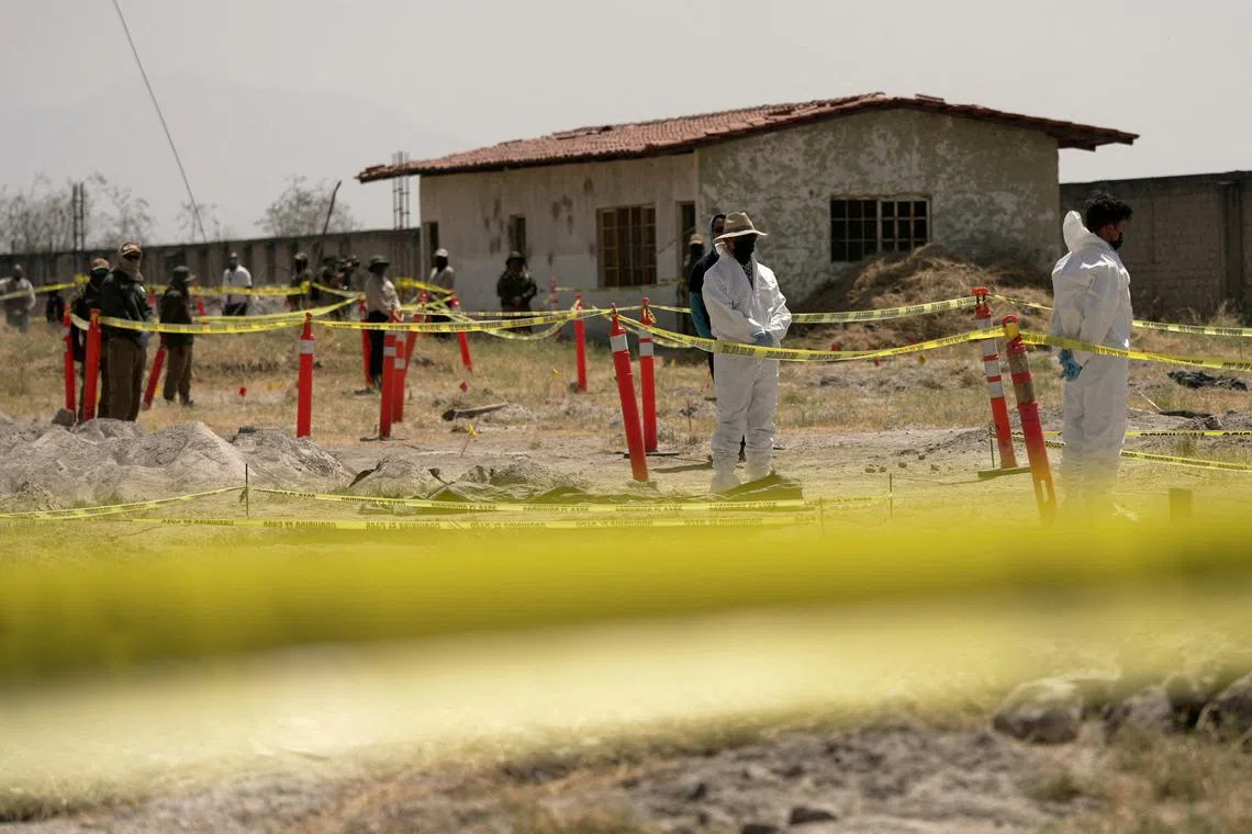 FILE PHOTO: Forensic technicians stand at a cordoned area during a media tour by Jalisco's Attorney General Office at Izaguirre Ranch, which activists have called a cartel-run \"extermination camp,\" in Teuchitlan, Jalisco state, Mexico March 20, 2025. REUTERS/Ivan Arias/File Photo