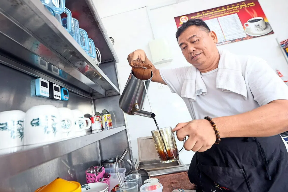 Coffee shop owner Kow Teck Phing, 59, making a cup of hot coffee at his eatery in Taman Daya, Johor Bahru, which is sold at RM2.30 per cup.