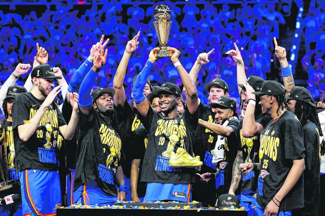 Shai Gilgeous-Alexander of the Oklahoma City Thunder celebrates with the Bill Russell NBA Finals Most Valuable Player trophy after defeating the Indiana Pacers 103-91.