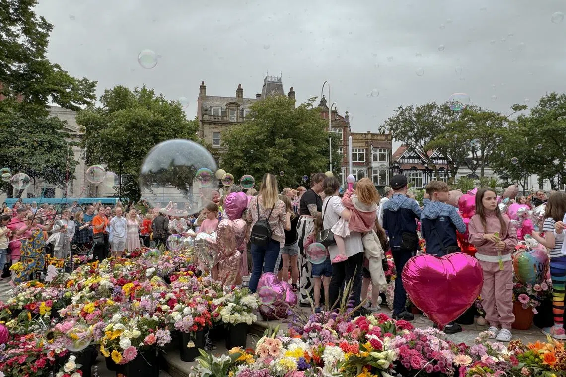 People blow bubbles at the \"Kisses to Heaven\" tribute to the victims of a knife attack, in Southport, Britain, August 5, 2024. REUTERS/Kirsten Donovan/File Photo