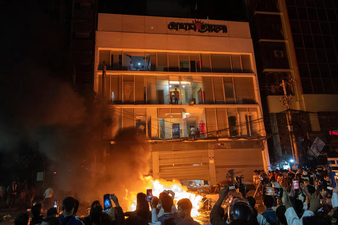 People using their mobile phone to film as the Prothom Alo newspaper office is attacked following the death of Sharif Osman Hadi, a student leader who had been receiving treatment in Singapore after being shot in the head, in Dhaka, Bangladesh, on Dec 19, 2025. 