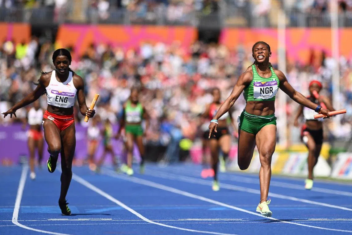 Nigeria's Nzubechi Grace Nwokocha (right) competing for first place followed by second-placed England's Daryll Neita in the women's 4x100m relay final athletics event at the Alexander Stadium, in Birmingham on day ten of the Commonwealth Games in Birmingham in August 2022. England's 4x100 metres women's relay team have been upgraded to 2022 Commonwealth Games gold after original winners Nigeria were disqualified because of a doping violation, it was announced Friday, July 14. (Photo by Glyn KIRK / AFP)