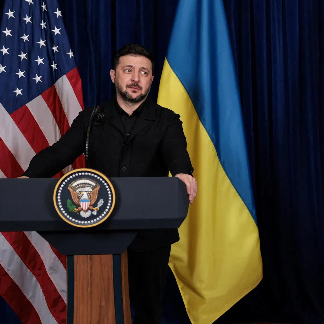 Ukrainian President Volodymyr Zelenskiy reacts after U.S. President Donald Trump said that Russian President Vladimir Putin expressed willingness to help Ukraine \"succeed\", during a press conference at Trump's Mar-a-Lago club, in Palm Beach, Florida, U.S., December 28, 2025. REUTERS/Jonathan Ernst