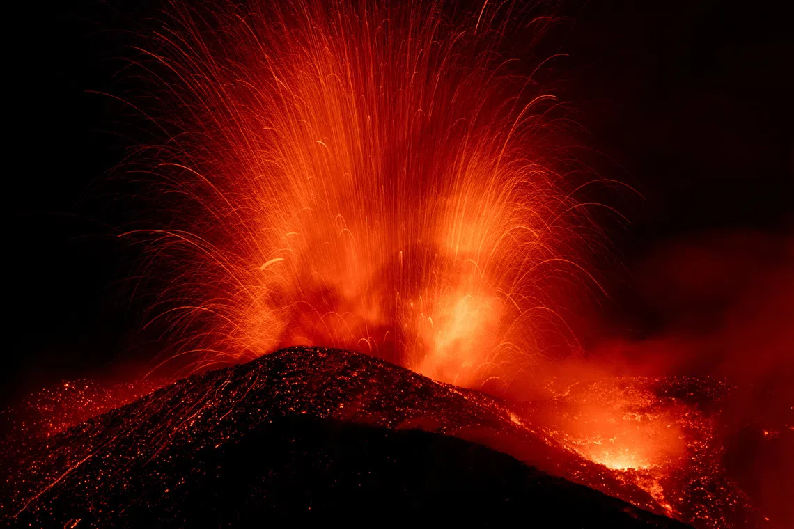 Incandescent lava and volcanic material are ejected from a crater during an eruption of Mount Etna, in Sicily, Italy, August 13, 2026. REUTERS/Giuseppe Di Stefano