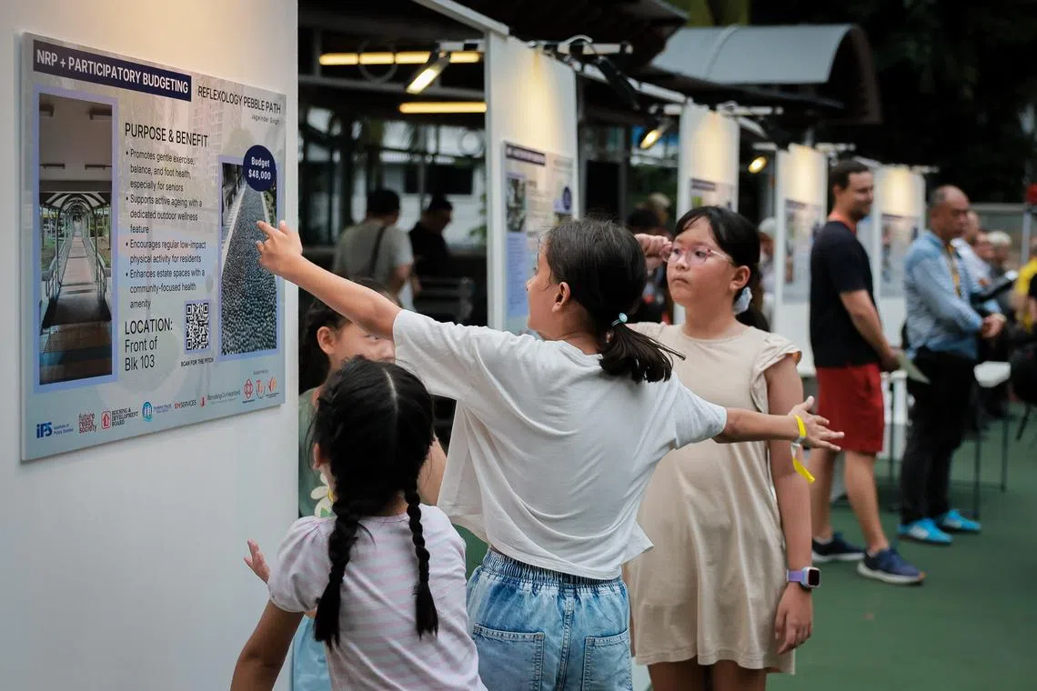 Residents look at proposals under the Participatory Budgeting component of the Neighbourhood Renewal Programme for selected HDB blocks in Spottiswoode Park at the amphitheatre on July 11.