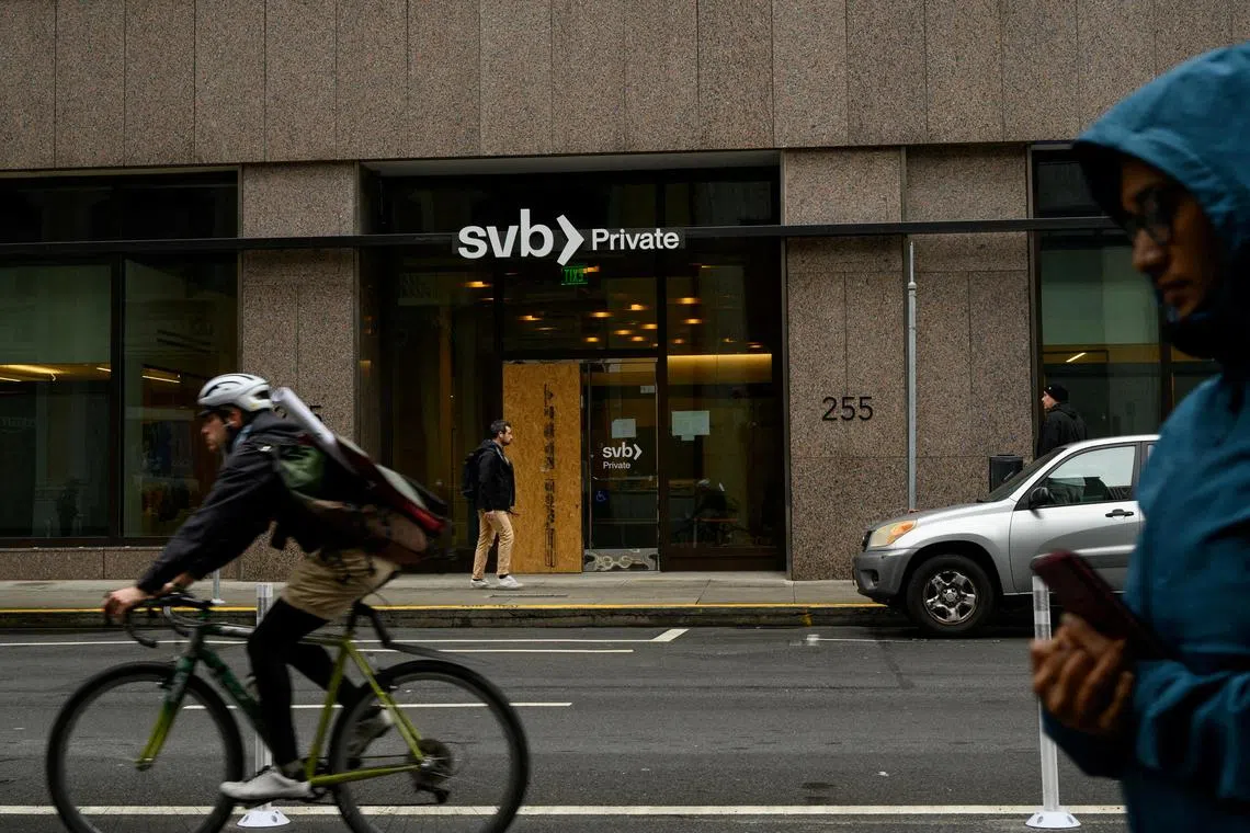  Pedestrians and a cyclist pass by the Silicon Valley Bank branch office in downtown San Francisco, California, U.S., March 13, 2023. REUTERS/Kori Suzuki/File Photo