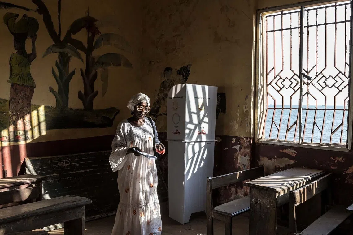 TOPSHOT - A voter leaves a voting booth after marking her ballot at the Federico Mayor Primary School during Guinea's presidential election, in Conakry, on December 28, 2025. (Photo by PATRICK MEINHARDT / AFP)