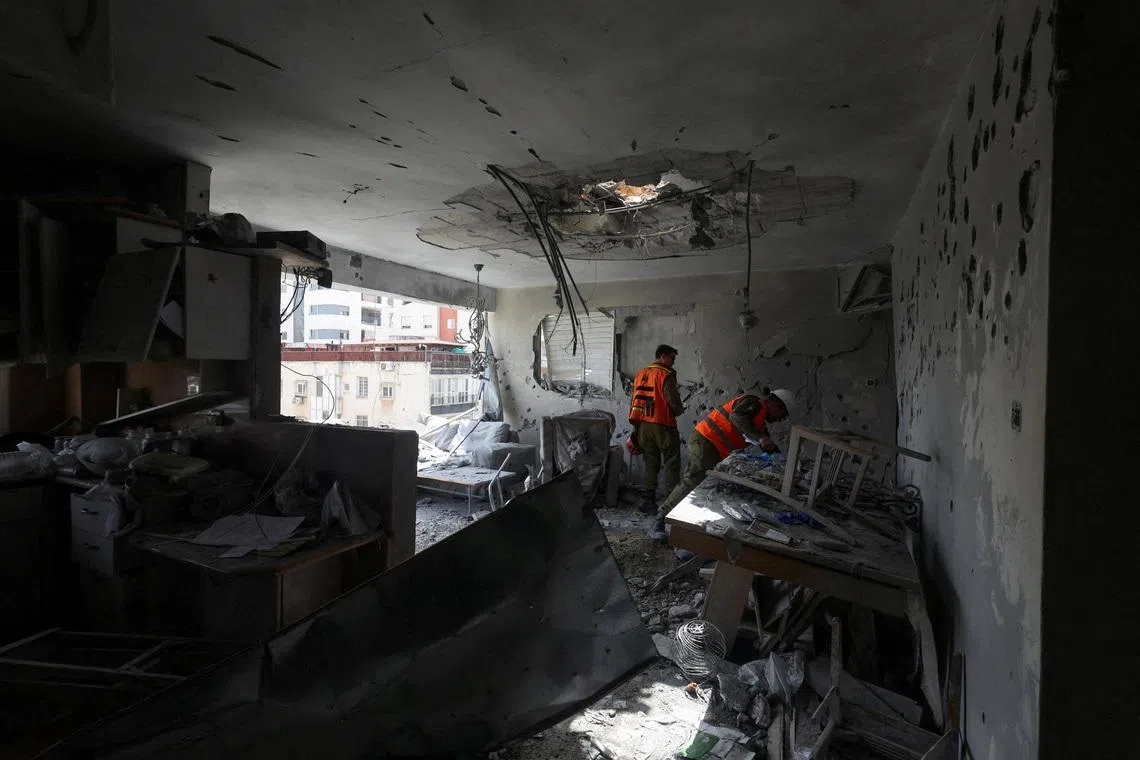 Soldiers inspect the remains of an apartment that was struck in a deadly Iranian missile attack, amid the U.S.-Israeli conflict with Iran, in Ramat Gan, Israel, March 18, 2026. REUTERS/Nir Elias